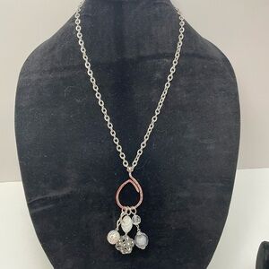 Silver tone charm necklace with round and square charms